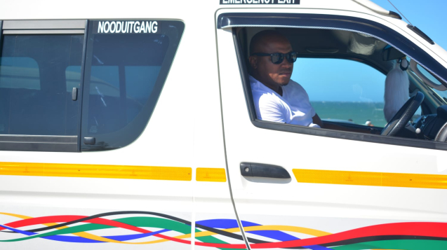 Mnr Tom, agter die wiel van een sy taxis.